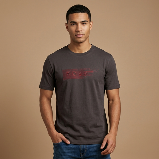 Man wearing a dark gray t-shirt with a red logo on a brown background